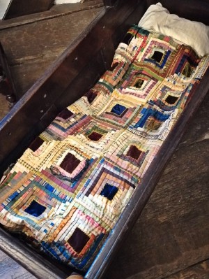 cradle with log cabin quilt